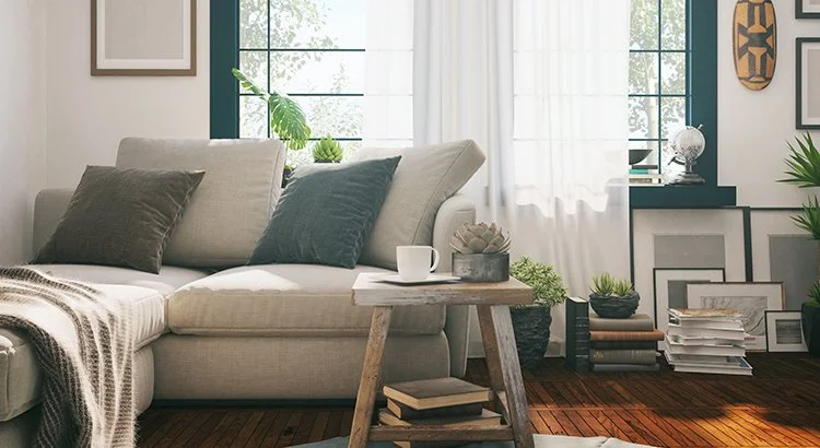 living room with coffee mug, couch, blanket, pillows