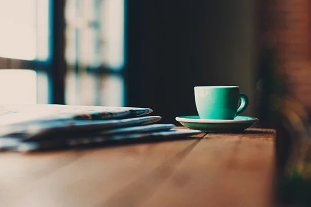 closeup of coffee cup on table with papers