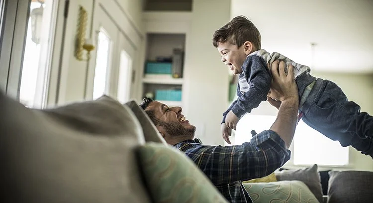 inside a home a dad playing with his son in  living room