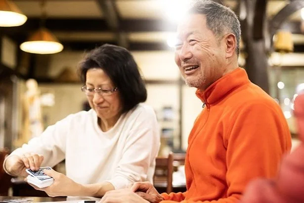 older couple playing cards in home