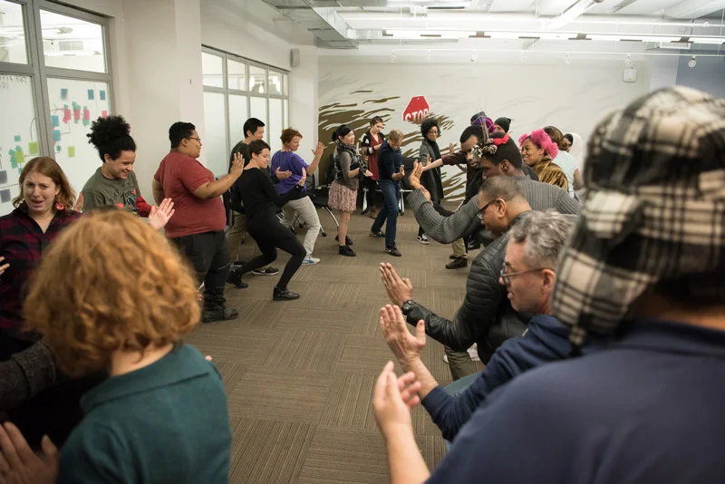 The audience at Theater of the Oppressed warms up together at a scene sharing workshop. Photo by Alex Woodhouse.