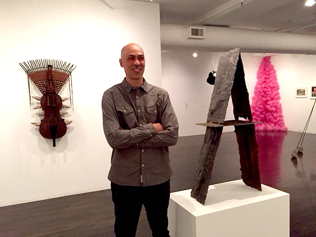 Roberto Visani with his cast iron sculpture Patterson Stack , 2016, at The 8th Floor.