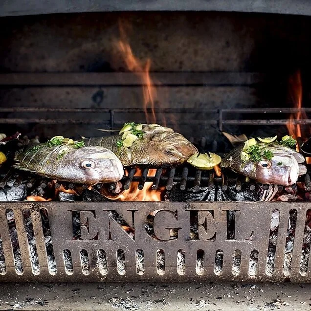 Fish cooked over flames on outdoor barbecue fire