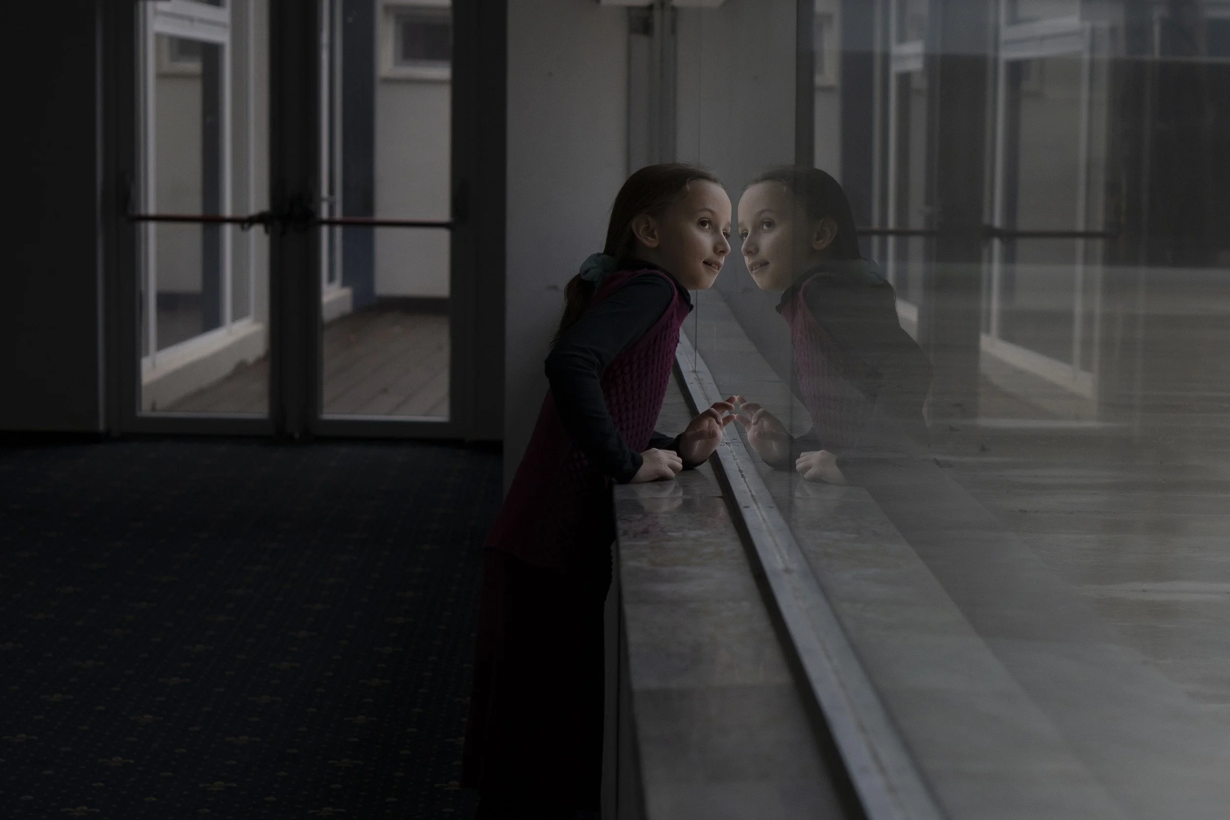  A girl looks out of the window from the hotel. 