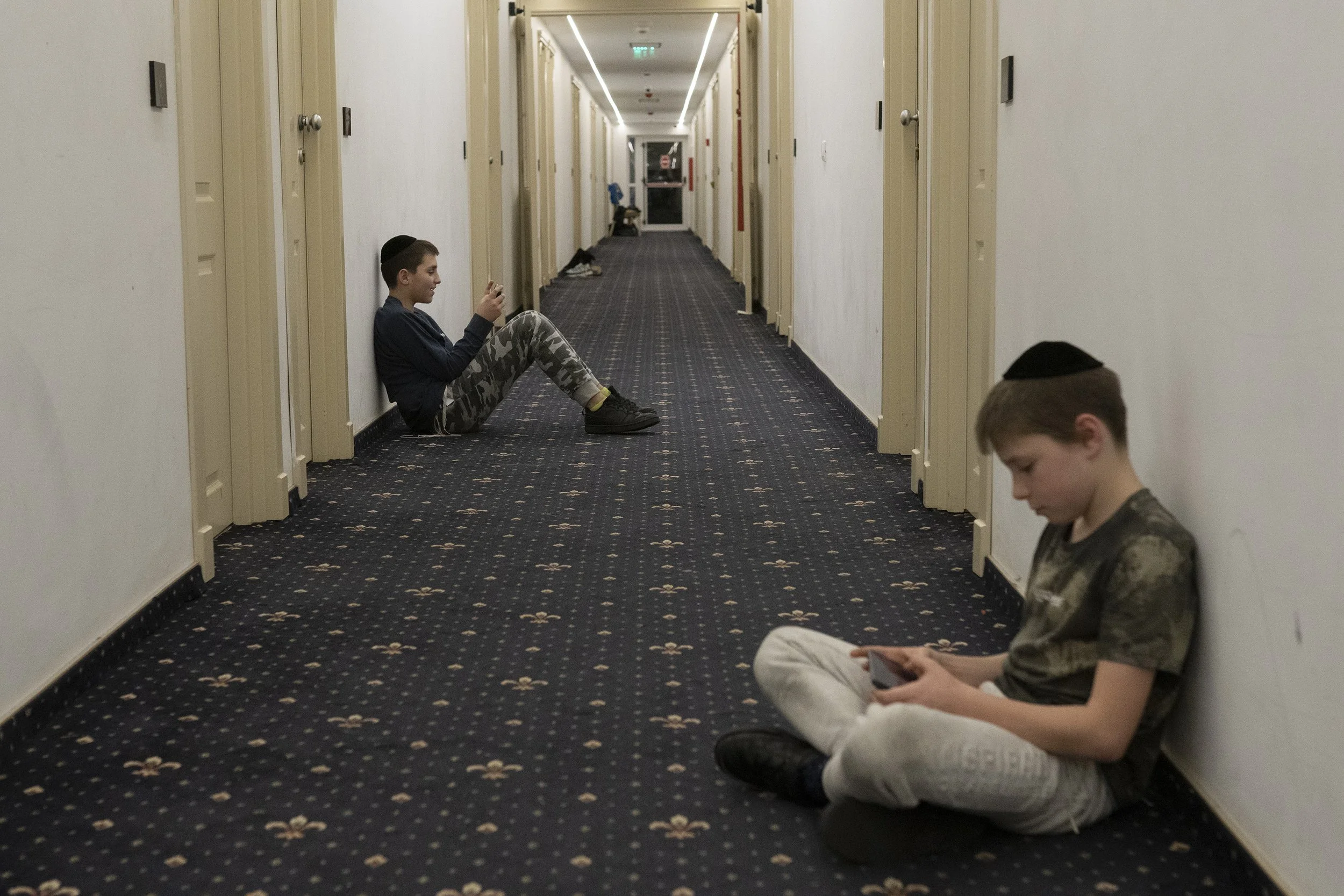  Two children play on their phones. 
