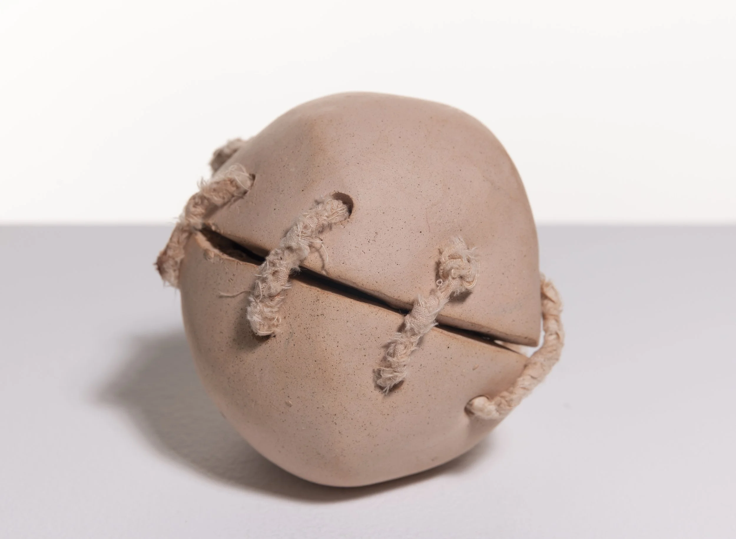 AlGhusain_Liane_Womb Amulets (2023). Stoneware, paper, rope hand-knotted from hand-dyed iron oxide cotton, 9 x 9 cm; sequence of 29.jpg