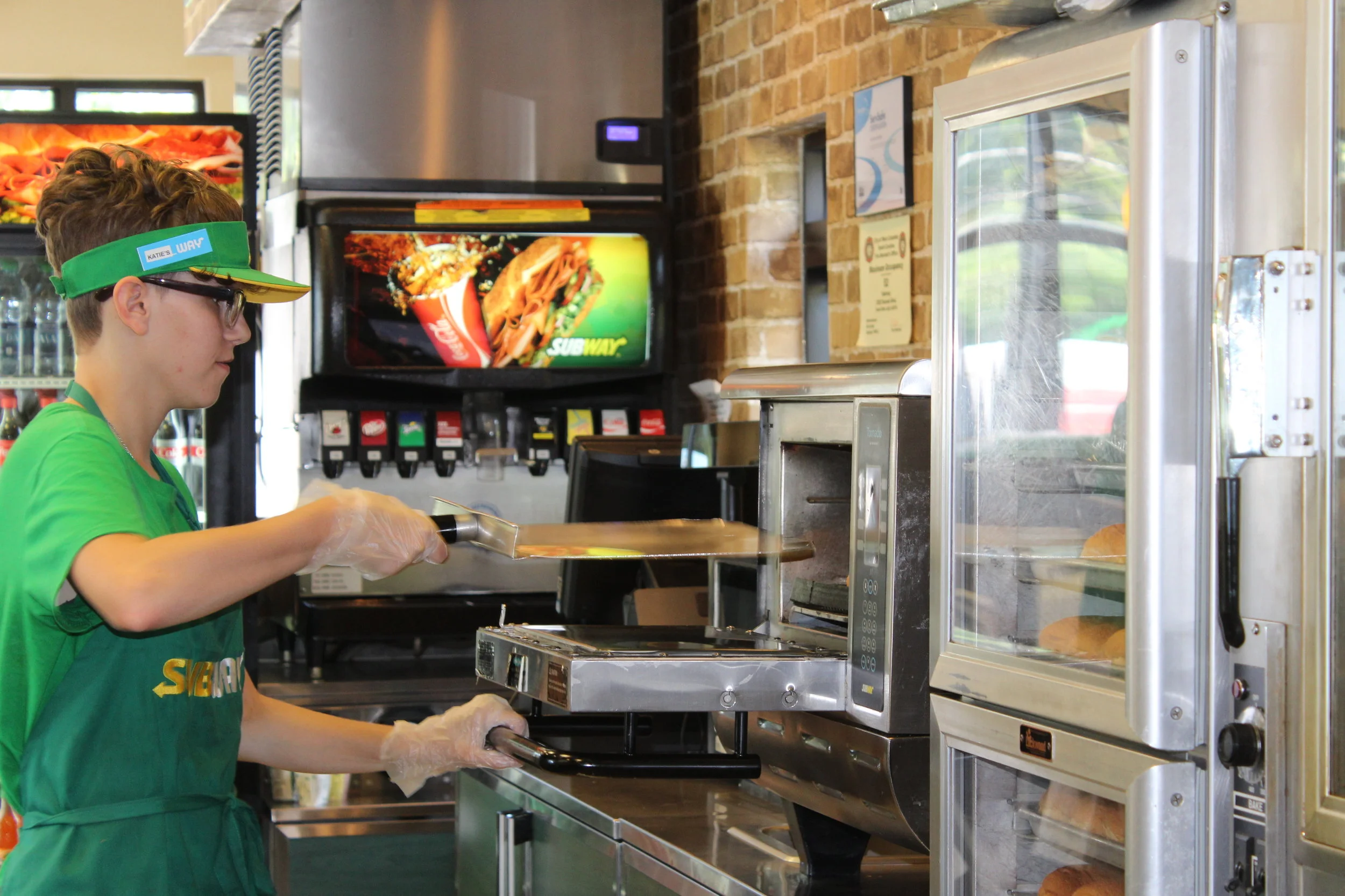Katie toasting a sandwich while at work