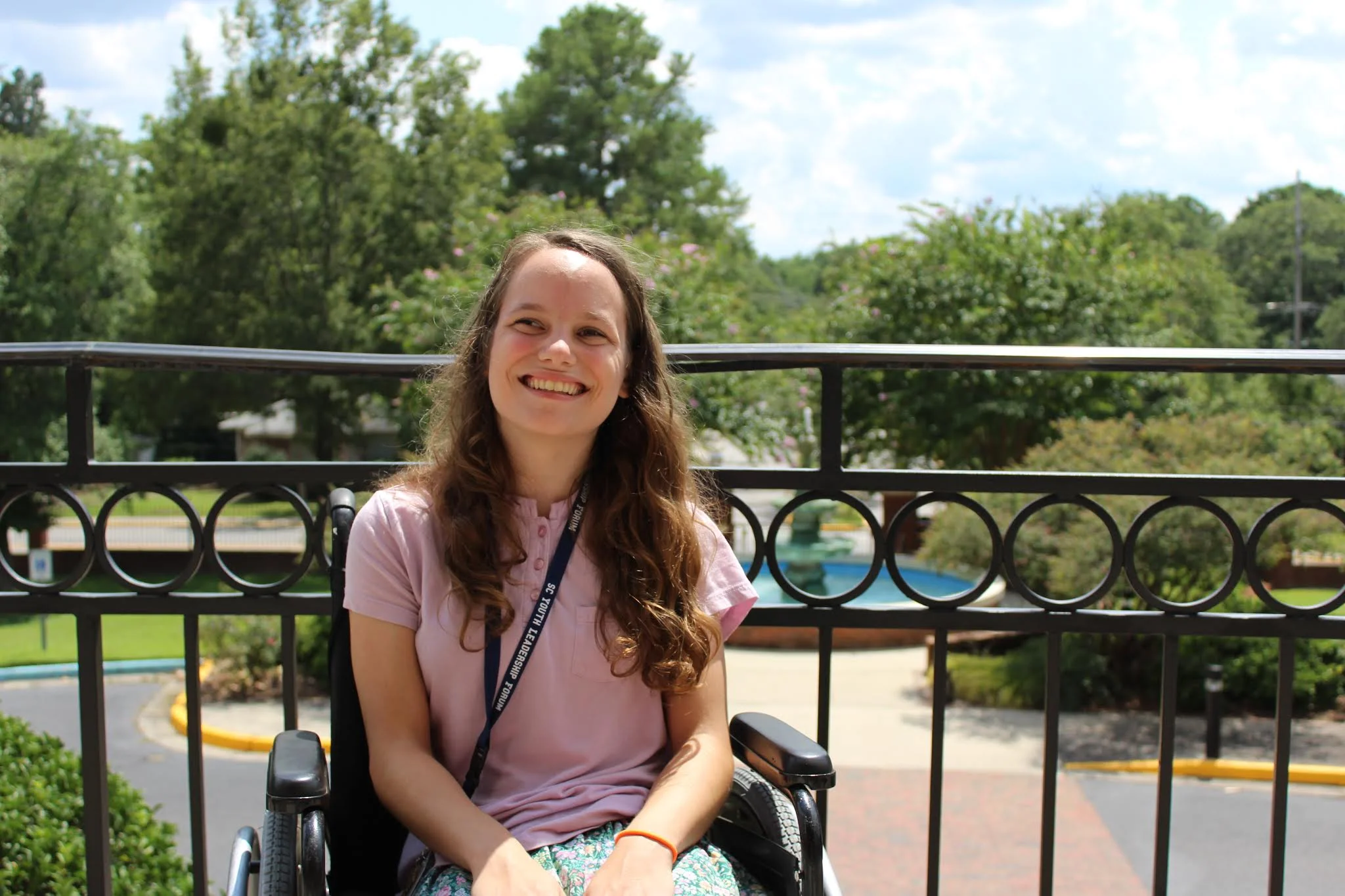 Photo of Julia sitting in front of a fountain and railing