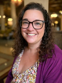 Tina, a white woman with curly brown hair and glasses.