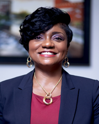 Felicia Johnson, a Black woman with cropped hair and gold jewelry in a suit.