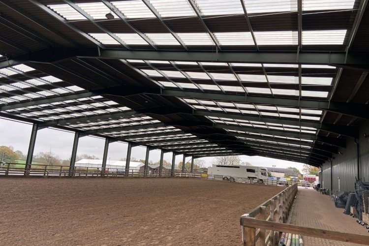 Covered equestrian riding arena with sand surface