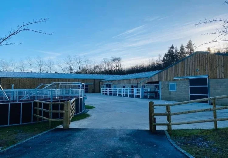 Modern equestrian yard with stables, fencing and outdoor arena.jpg
