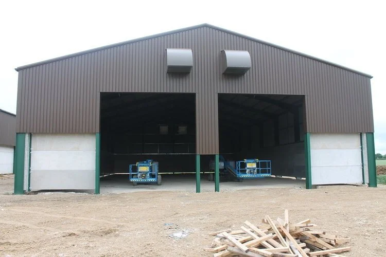 Agricultural grain storage building with large open access doors