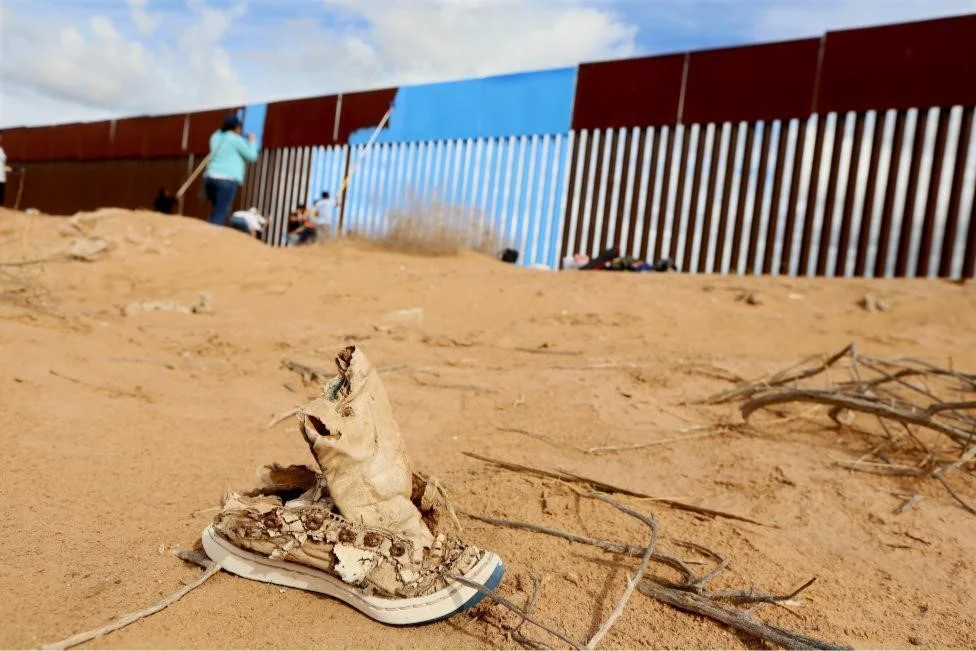 Volunteers paint the border fence in Mexicali, Mexico. REUTERS/Sandy Huffaker