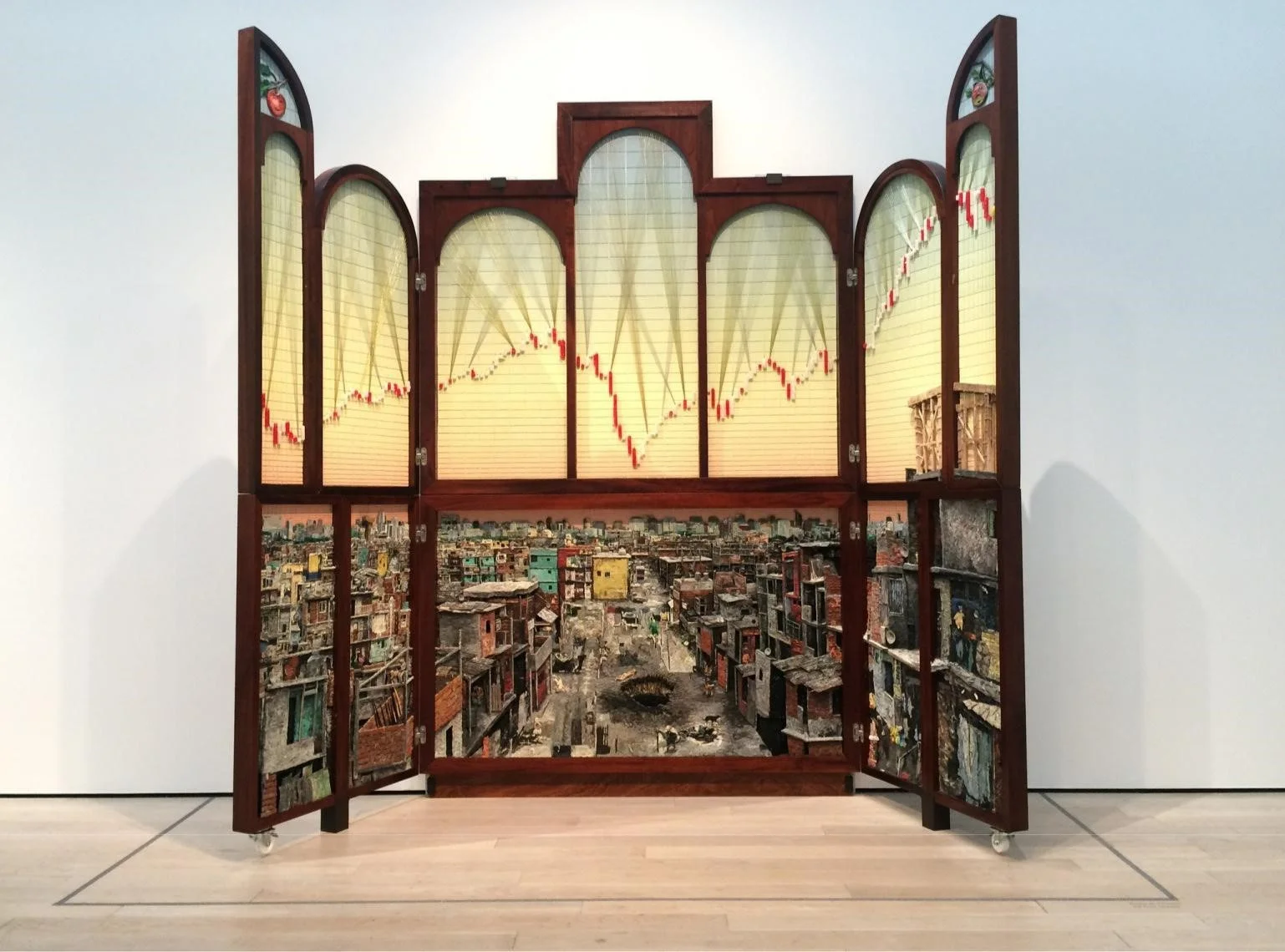 "Políptico de Buenos Aires" (2014/2016), by the collective Mondongo, shows the disparities of wealth in the Argentine capital. (Carolina A. Miranda / Los Angeles Times) The exhibition, as Ramirez observes, is not a strict chronological survey of important works by important artists. Instead, it functions more as “a constellation” — “putting works in dialogue with each other across generations and countries” in ways that connect on the level of ideas or materials. “We wanted to see what work talked to other work,” Noriega adds. “We saw work talking to work from other countries — even if they might be 50 years apart.” A pair of wall-hangings by Raphael Montañez Ortiz, a U.S. artist of mixed Caribbean and Mexican heritage who made some of his key works in the 1960s, for example, hang adjacent to an installation by Colombian artist Leyla Cardenas, who has been active for just over a decade. Both pry apart domestic settings to examine their psychological and historical roots. Ortiz’s pieces, which he labels “Archaeological Finds,” consist of dismembered furnishings that he pries apart in violent acts. Cardenas uses elements of old architecture to conduct what amounts to archaeological digs. Taking slivers of a decaying 19th century house from Bogotá, she’s peeled away layers of wallpaper to reveal decorative elements dating back to the early republic. The structure was made of wood and adobe, in the Spanish style, but the wallpaper added after independence is English. It marks a moment in which Colombia was searching for a new identity apart from Spain. All of this she presents as a 4-inch-wide slice of a room that looks like a laboratory specimen on an architectural scale. “From a piece of the room, you can reconstruct not just the room, but the house and the city and the country and what was going on at any given time,” she says. “It fits with the show, which offers a transversal look at the concept of home.”