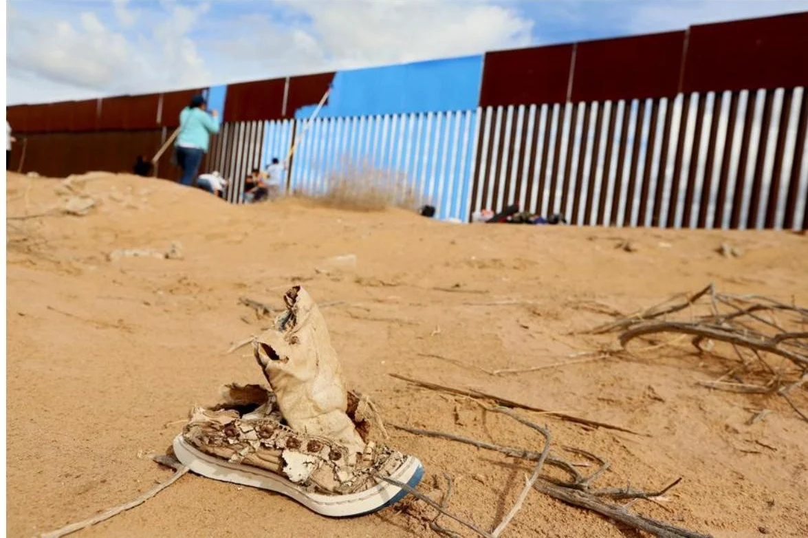 Volunteers paint the border fence between the United States and Mexico in Mexicali, Mexico, on April 9, 2016. # Sandy Huffaker / Reuters