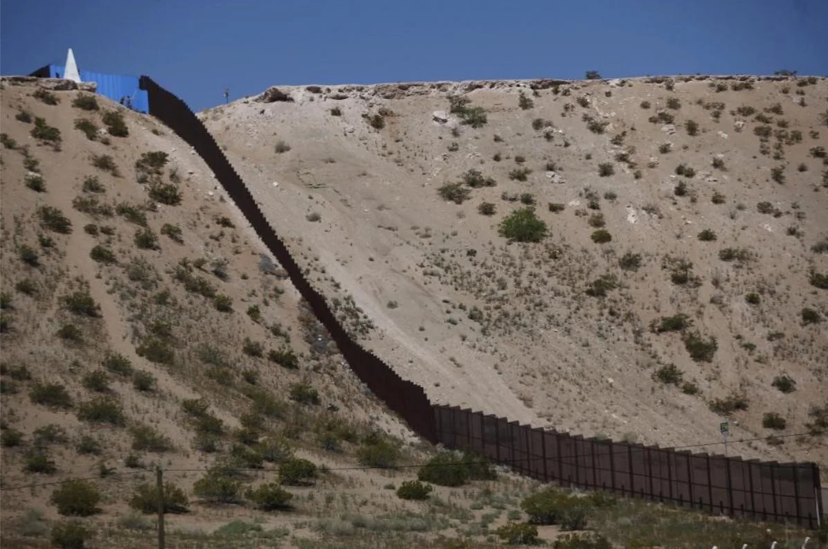 Part of the border fence is seen after artist Ana Teresa Fernandez and members of cultural organization "Border/Arte" painted it, to give it the illusion of transparency in Ciudad Juarez, Mexico. REUTERS/Jose Luis Gonzalez