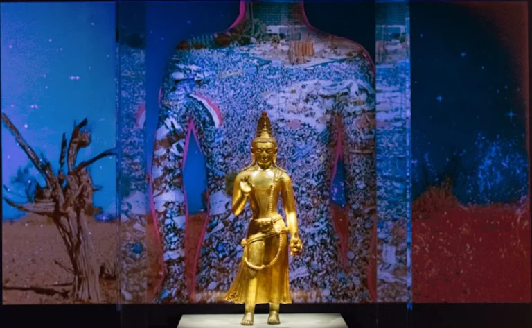 Chitra Ganesh, still from the digital animation ‘Silhouette in the Graveyard,’ 2018, behind ‘The One of Loving Kindness Maitreya,’ Mongolia, late 18th–early 19th century | Digital still courtesy of Chitra Ganesh/collection object image courtesy of the Rubin Museum of Art.