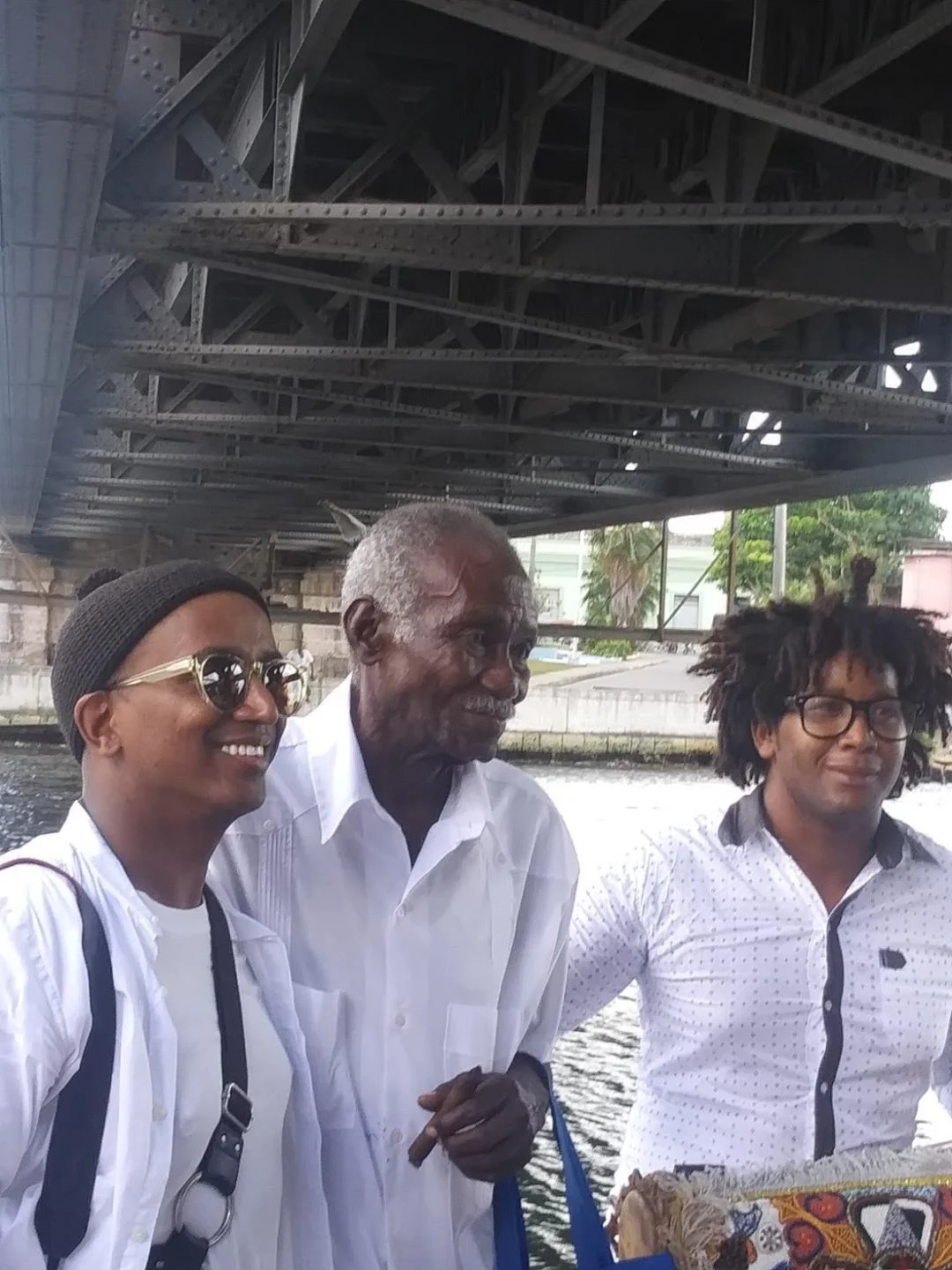After the performance, artist Dawit L. Petros, left, poses with his mentor on the project, center, and the drummer who performed on the river wall Photo: Cuban Art News