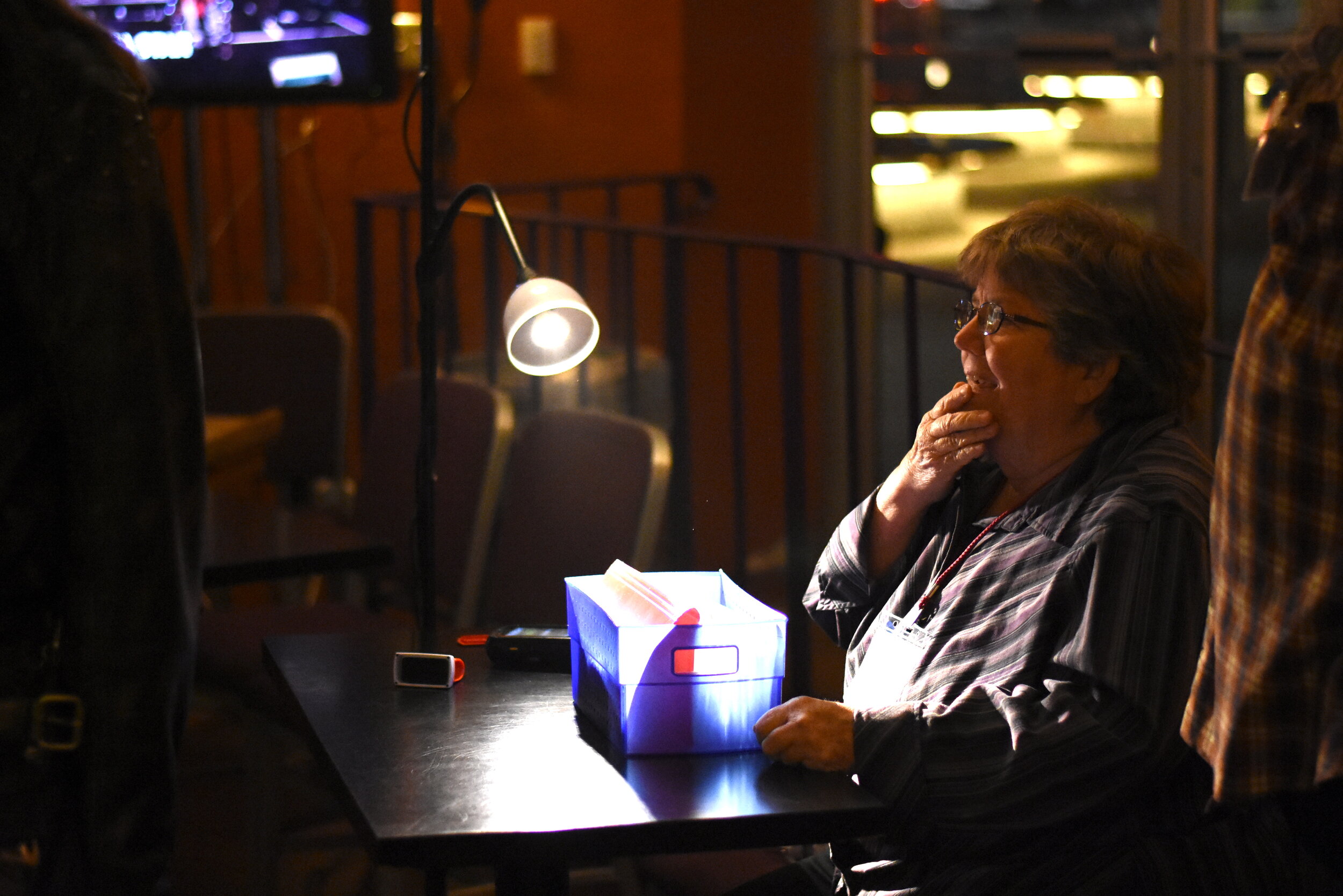 Volunteer Maggie Tuff checks in an audience member in the lobby