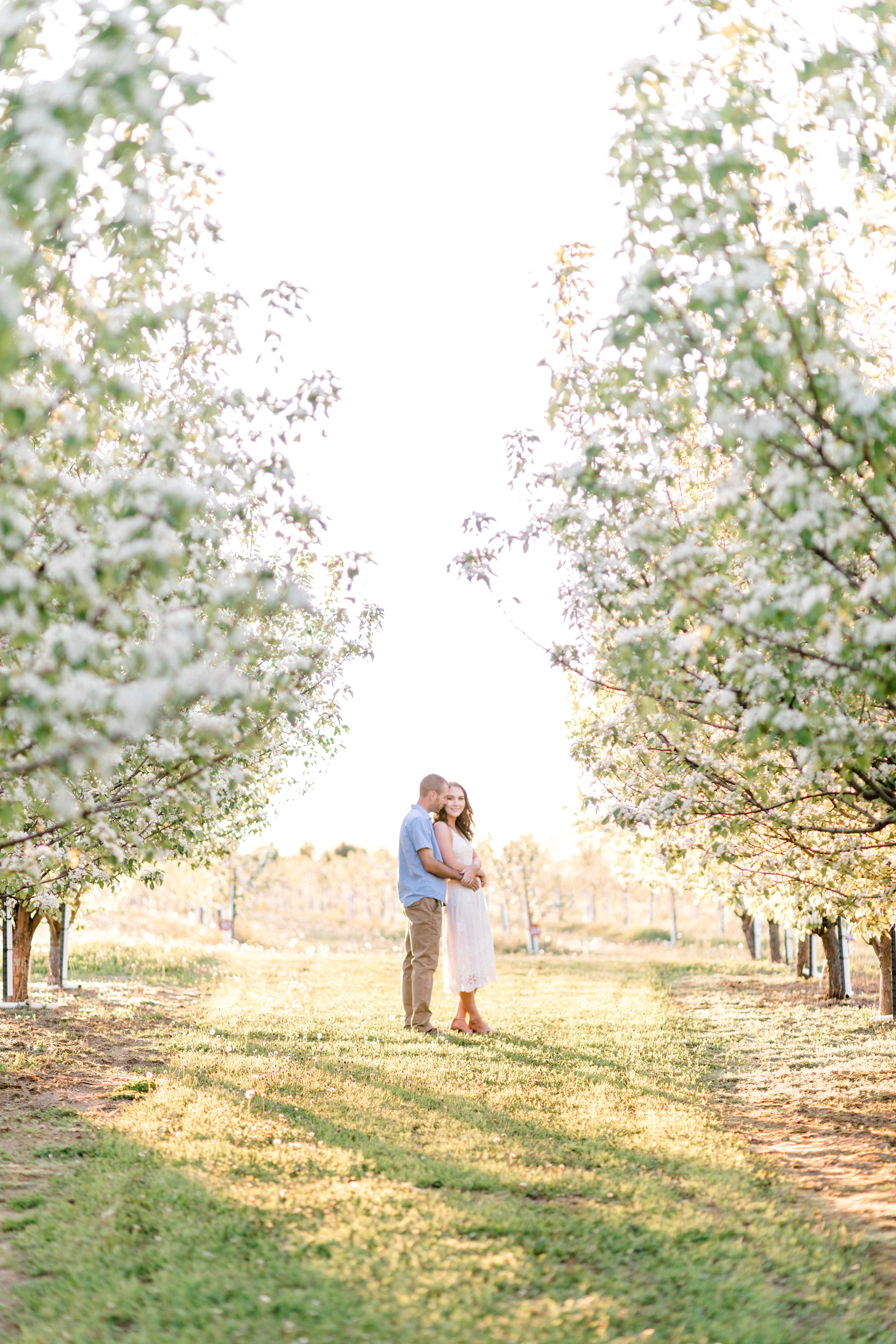 Sweet, outdoor engagement pictures should be romantic and fun! This golden glow session was jus that. Sunrise orchard engagement photo ideas with flower blossoms.