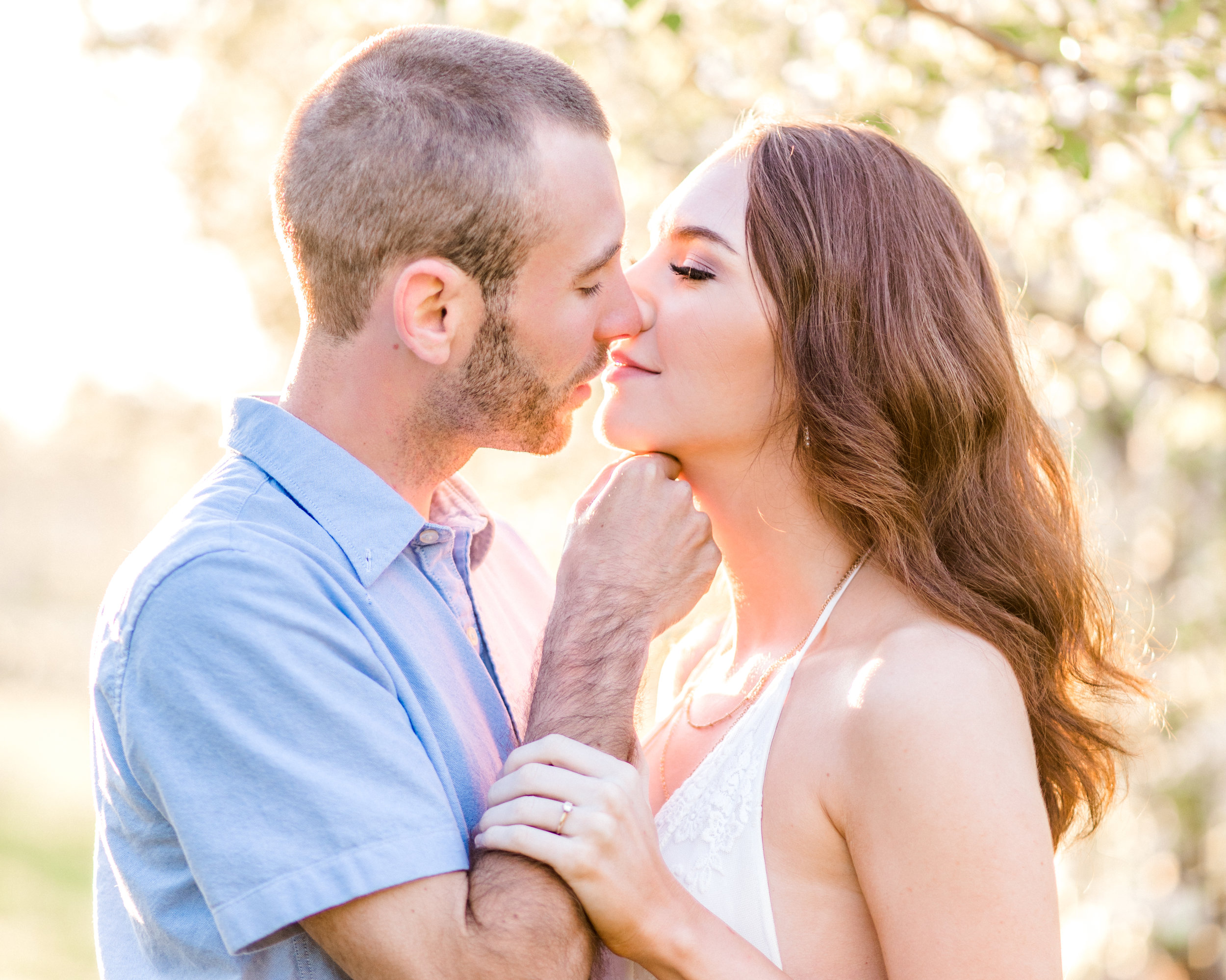 Springtime engagement pictures should be romantic and fun! This golden glow session was jus that. Sunrise orchard engagement photo ideas with flower blossoms.