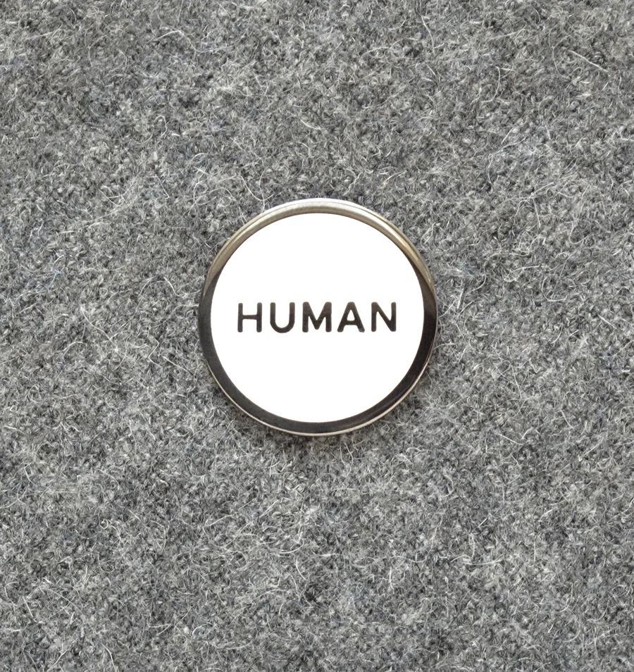 “Human” enamel pin, $10