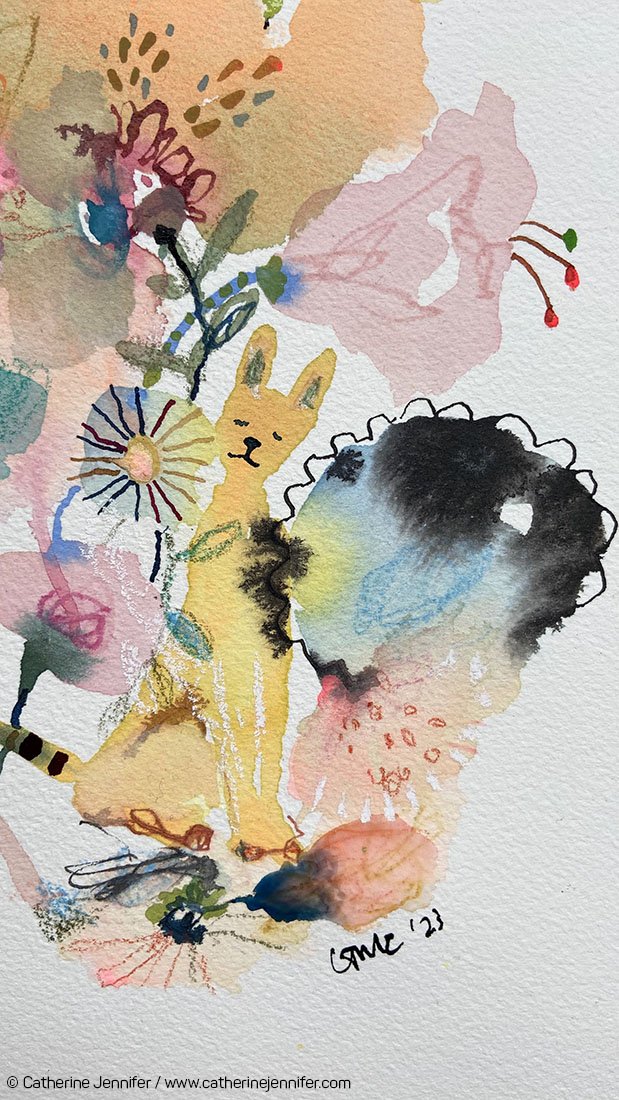 Close-up of the yellow cat peeking through colourful flowers beside a dramatic blue and black bloom.
