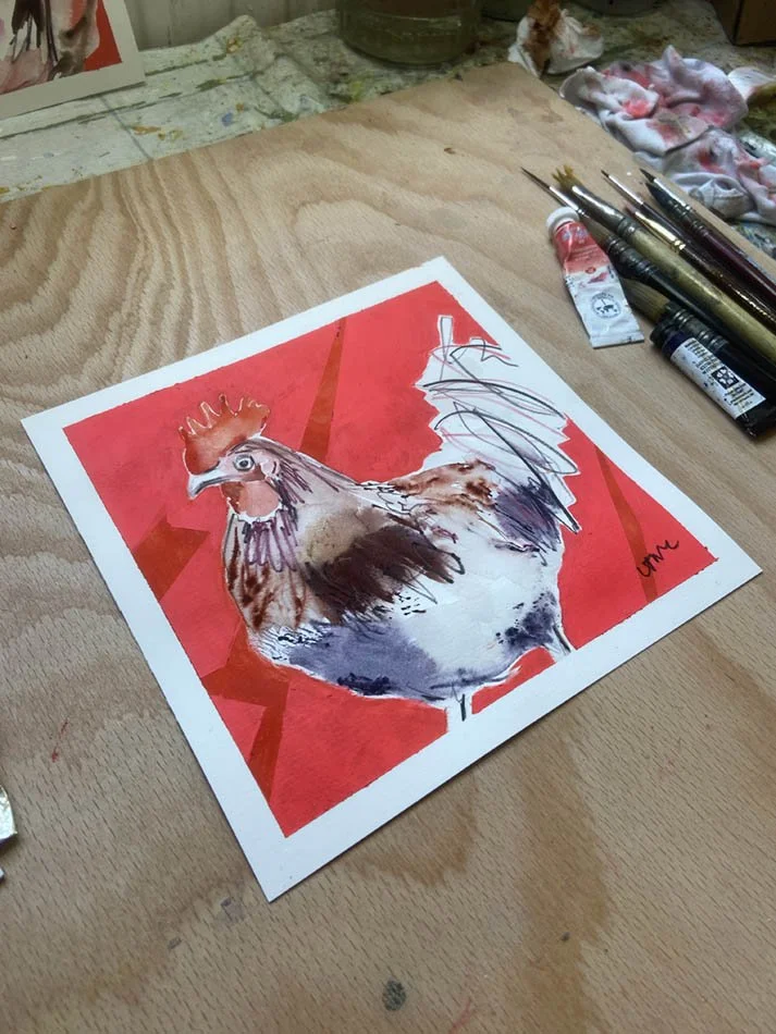 Colourful watercolour painting of cockerel in artist's studio