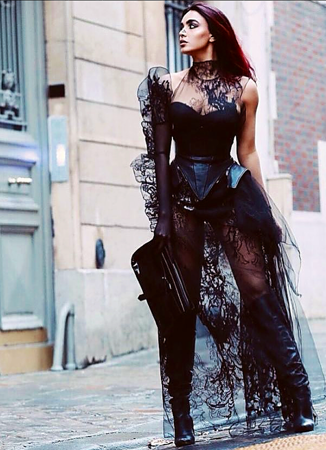 A woman riding a bicycle in front of a building.