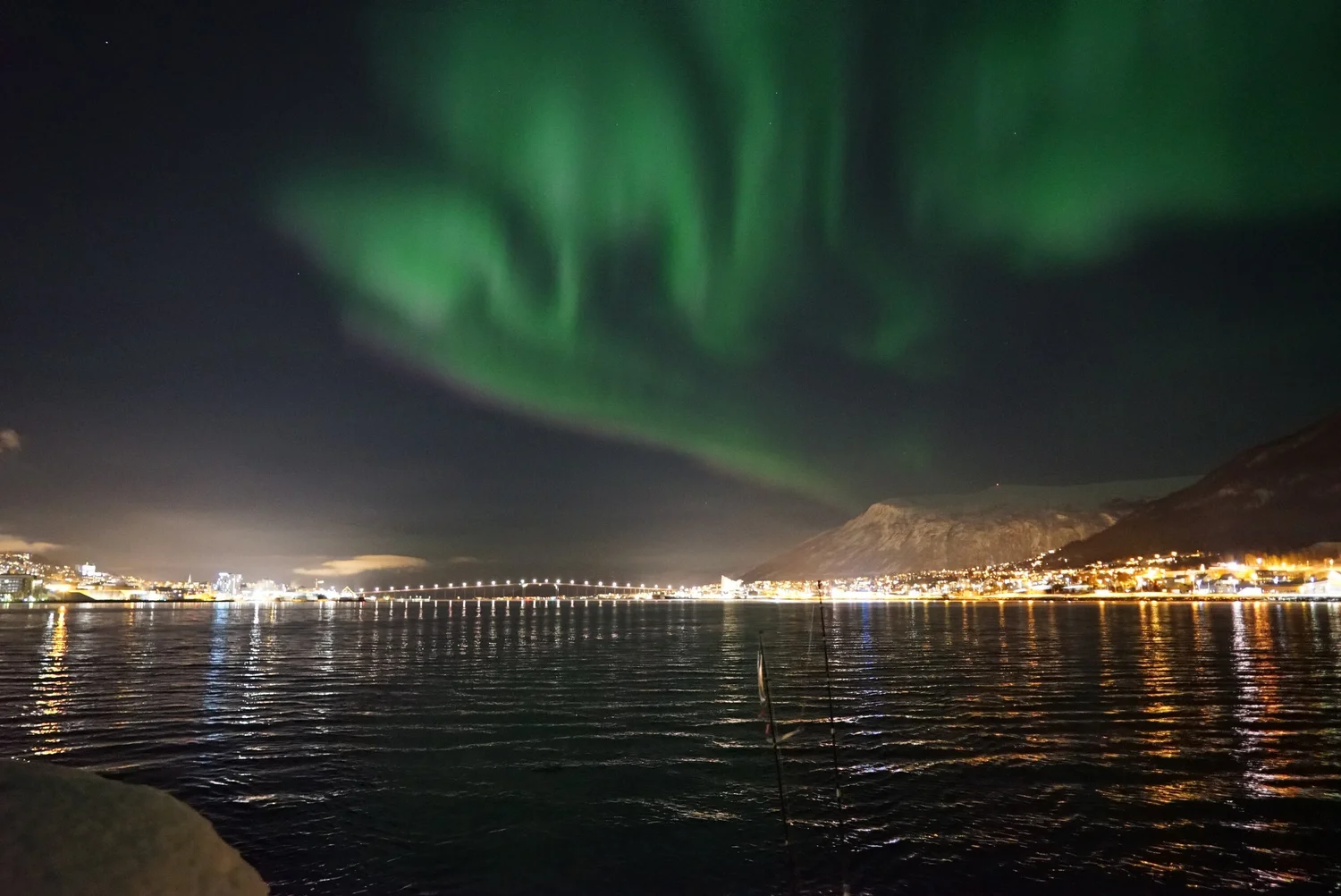 Northern lights dancing over the fjords near Tromsø