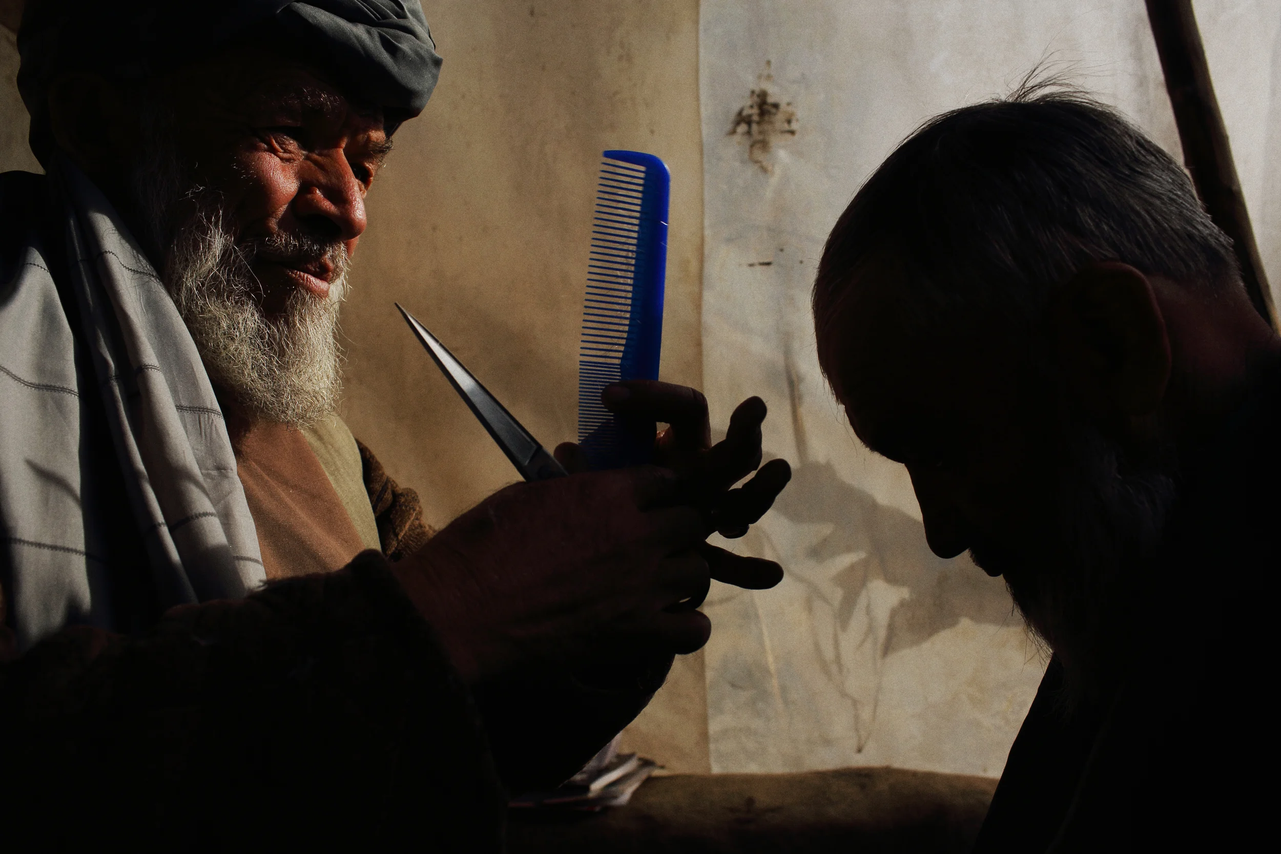  A double-amputee working as a street-side barber. Kabul, January 2014. 