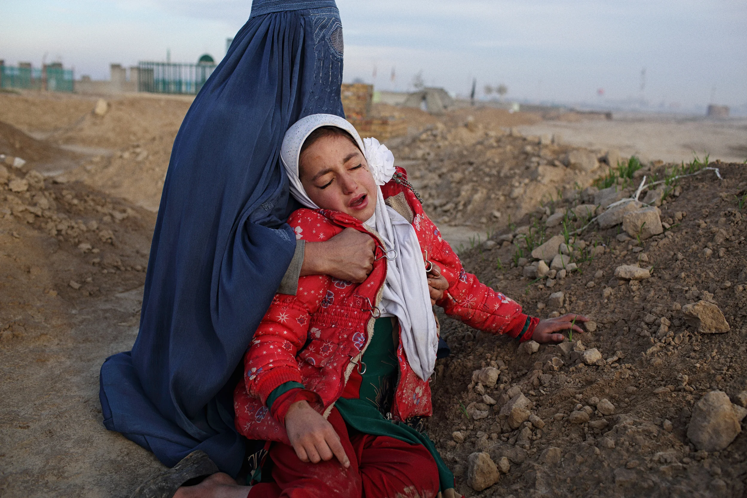  Baynazar’s widow Najibah tries to comfort her daughter Zahra during a visit to his grave a month after his death. Kunduz Province, November, 2015. 