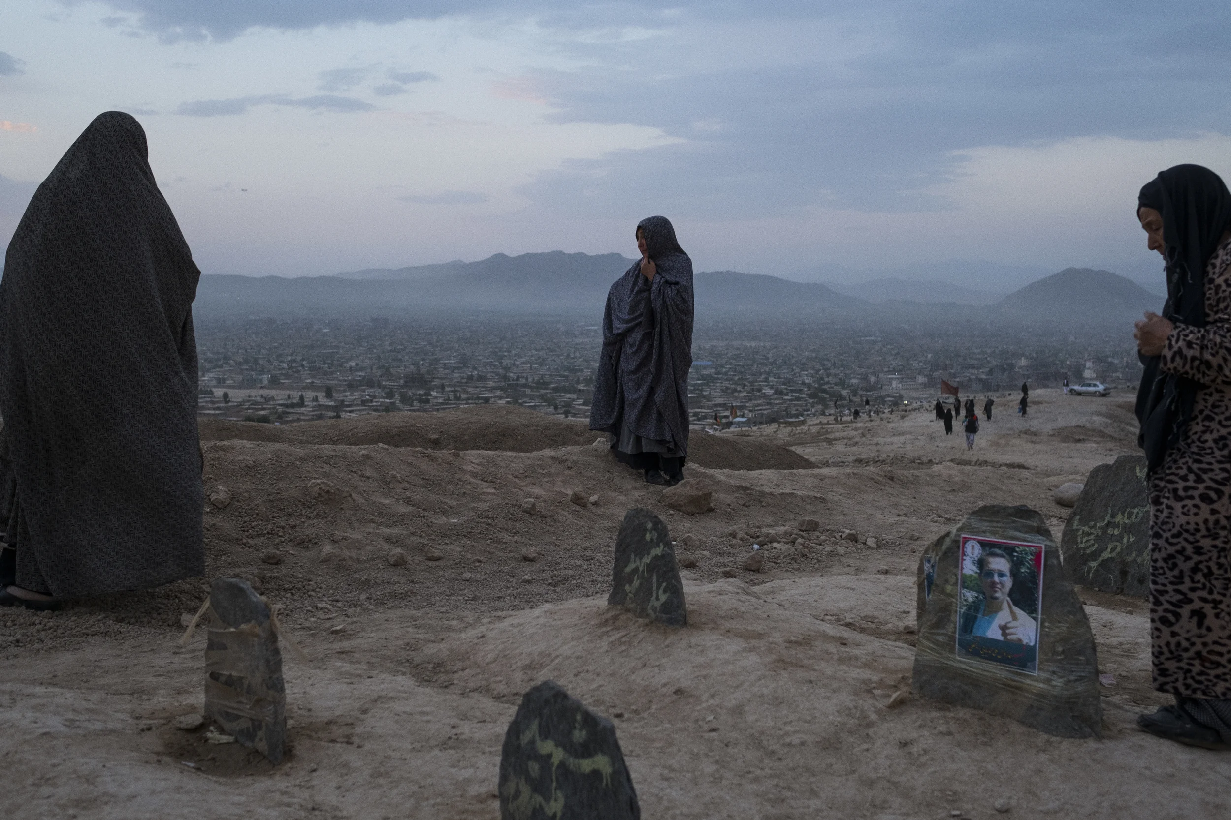  Female friends and relatives mourn the 25 ethnic Hazaras who were buried in a mass grave on a hilltop on the southern outskirts of Kabul after a double suicide bombing claimed by the so-called Islamic State Khorasan Province killed more than 80 duri