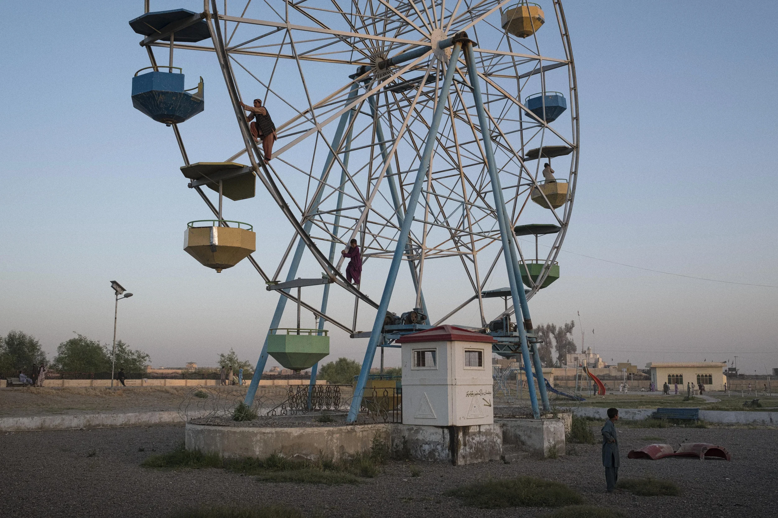  Young boys climb a broken-down Ferris Wheel in order to give a friend a quarter of a revolution ride, in a dilapidated playground in the Lashkar Gah. The Ferris Wheel is long-defunct, with little incentive for local investors to spend money in a cit