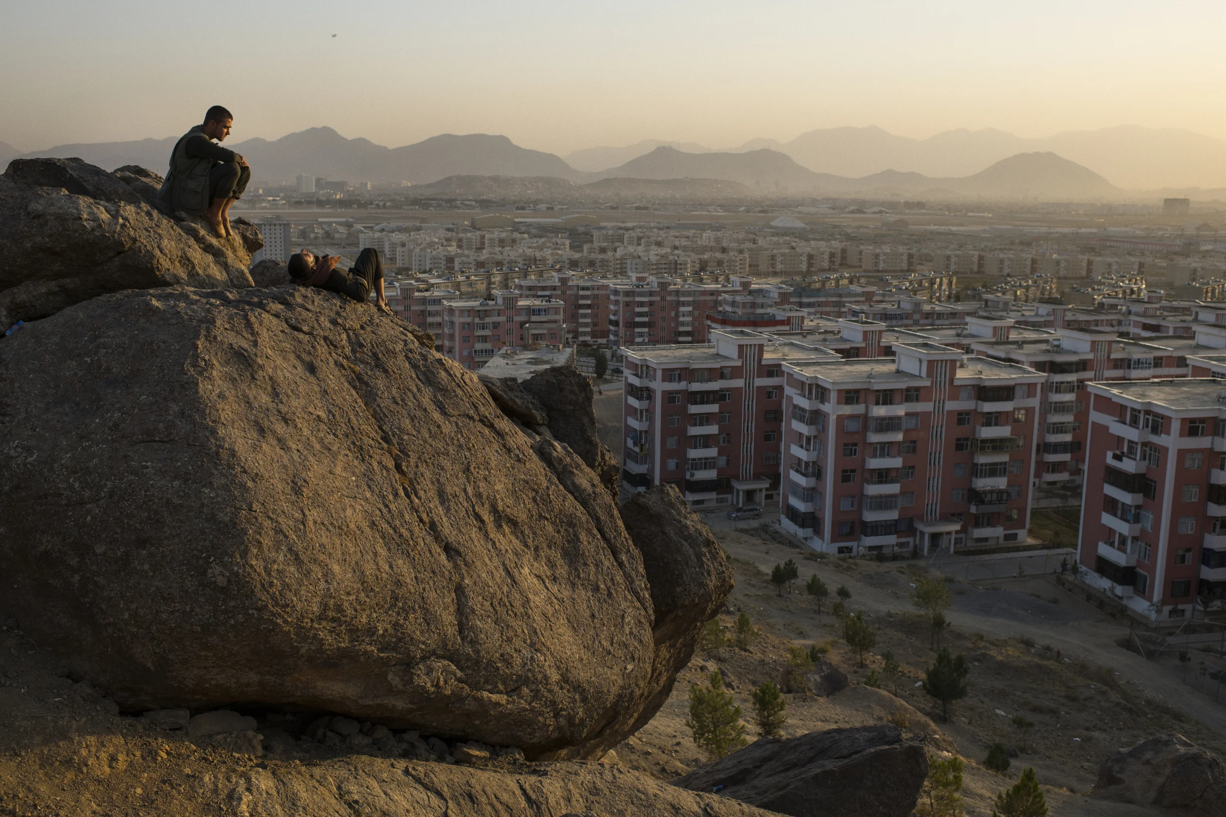  Samim Sediqi and Iqbal hang out on a boulder, enjoying the sunset above the Khwaja Rawash apartment complex, where they have been residents for two and a half years. Kabul, September, 2017. 