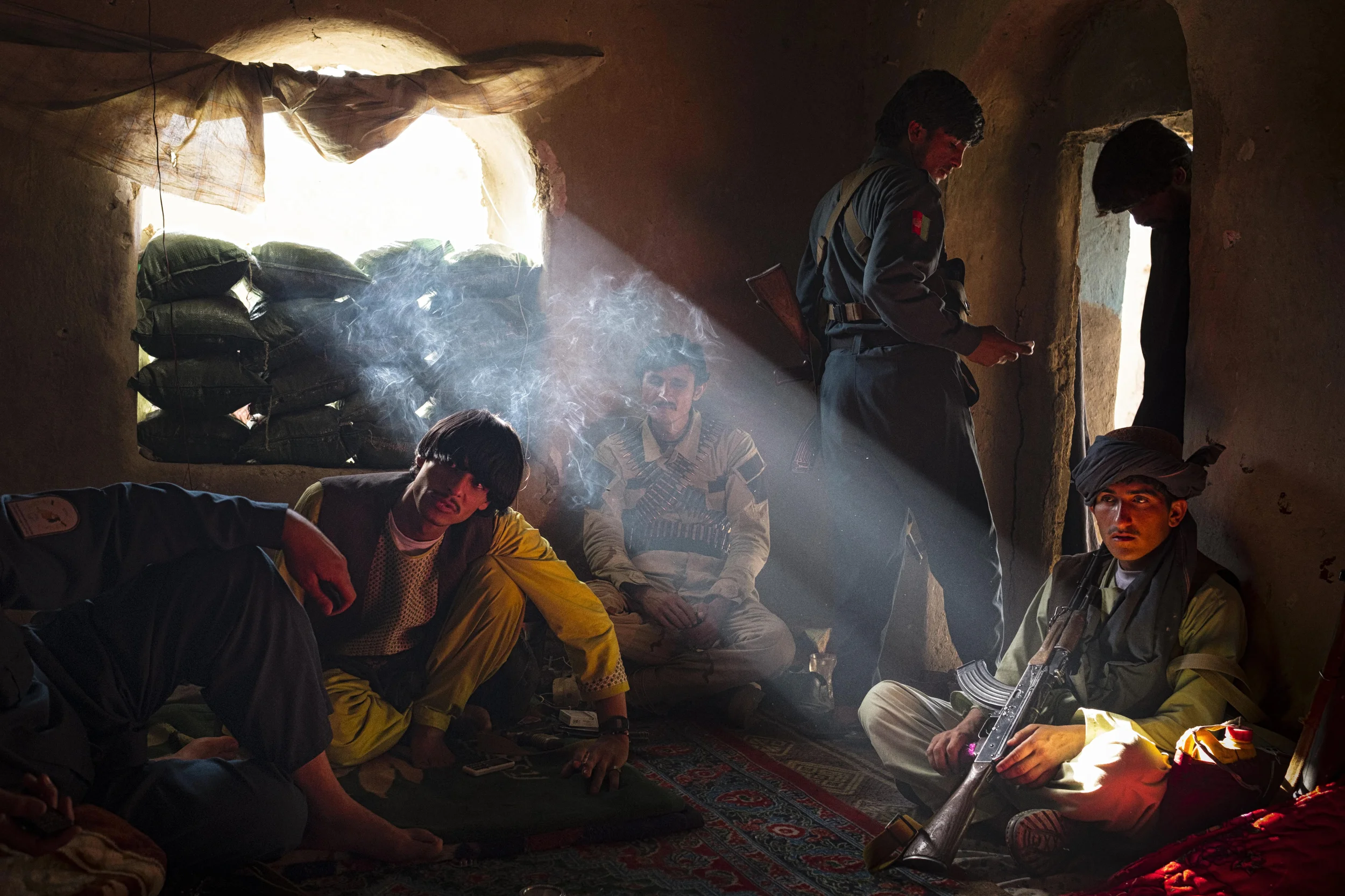  Afghan National and Local Police inside a compound on the frontline in Chahr-i Anjir. A Taliban position is visible less than 100 metres away. Two weeks later, the compound was ambushed and two policemen killed. Helmand Province, April, 2016. 
