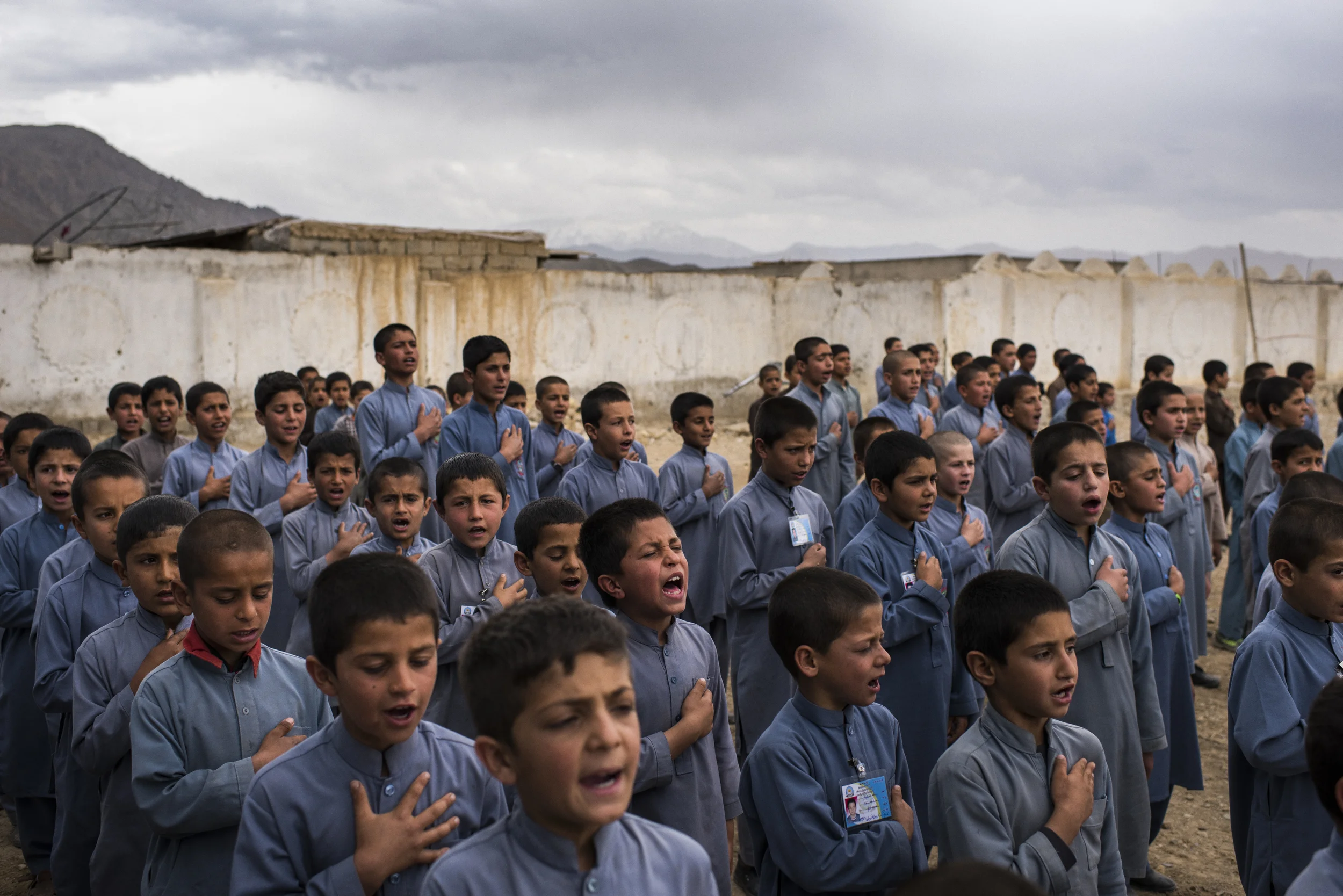  A little over an hour from the Afghan capital Kabul, in the province of Logar, which is heavily contested by Government and Taliban forces, students from a private school in Muhammad Agha District sing the Afghan national anthem during assembly. Log