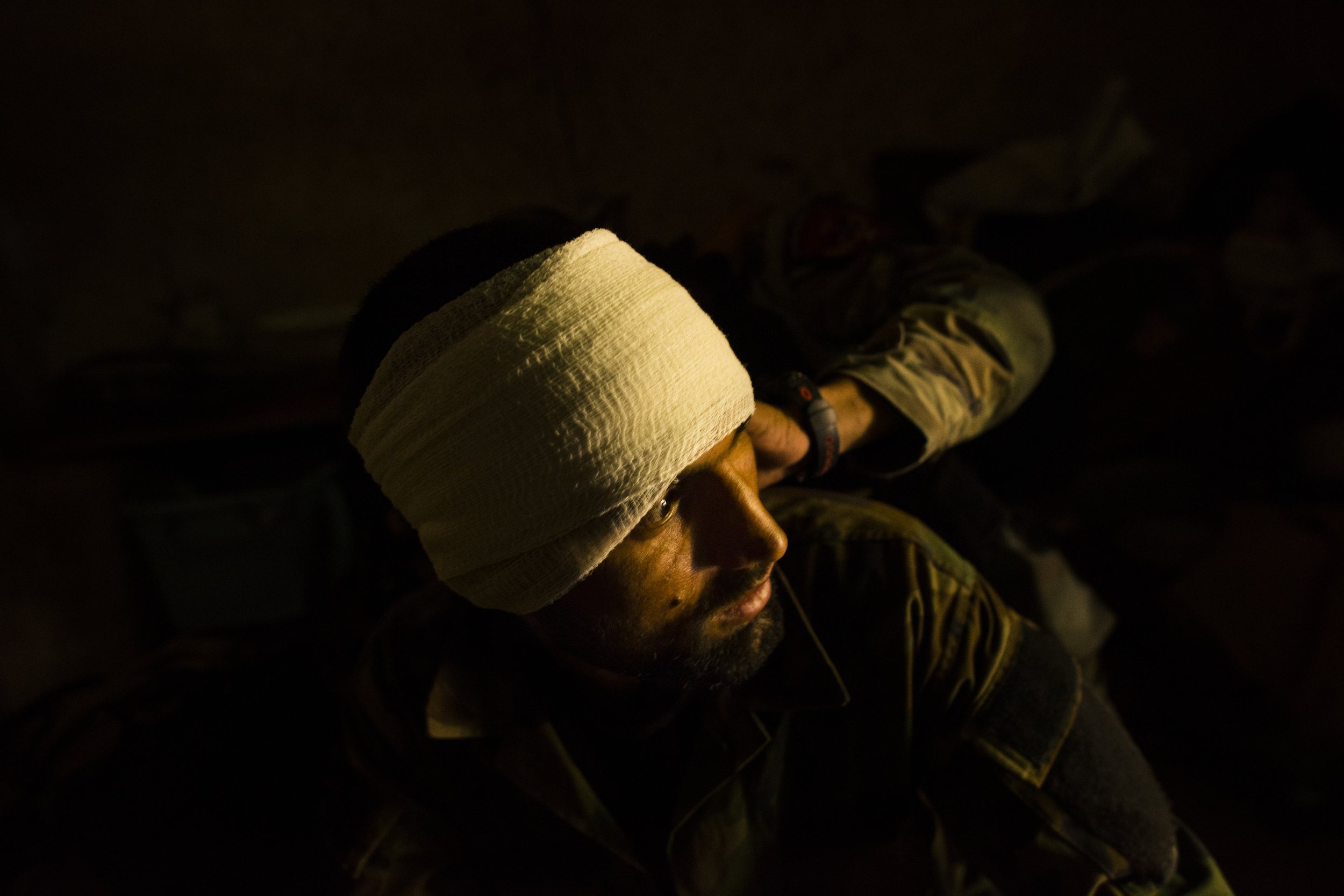 An Afghan National Army soldier has a bullet wound bandaged by a commando medic after the compound they were occupying in Chahr-i Anjir, outside Lashkar Gah, was ambushed by Taliban fighters. Helmand Province, August, 2016. 