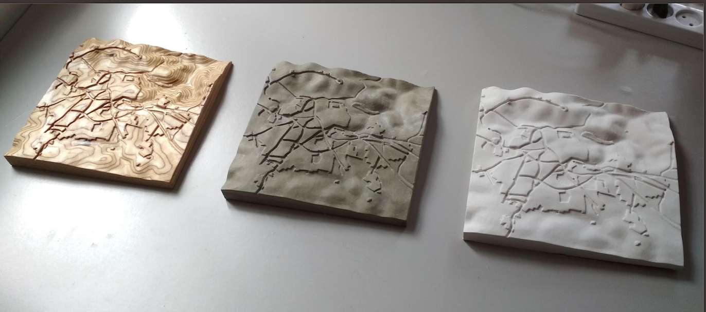 Samples of the 3-dimensional topographic pieces based on British survey maps. Left-to-right: CNC cut plywood, concrete cast and plaster cast.