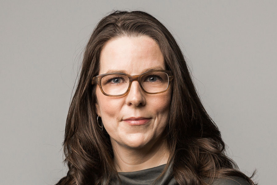 Middle aged woman with long dark hair and glasses