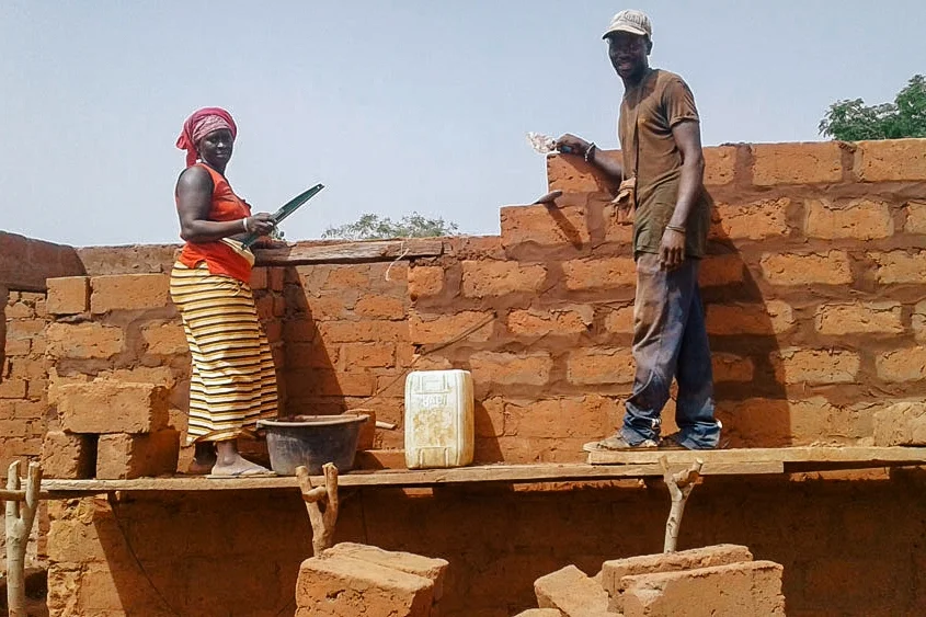 Community members laying bricks