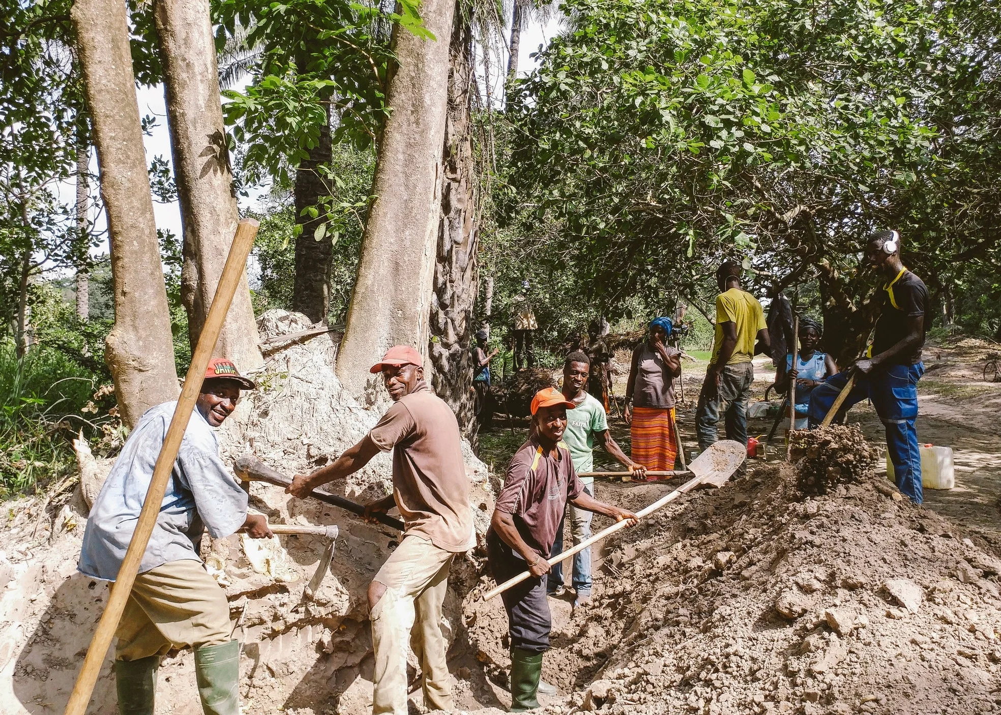 Laborers dig drainage ditches alongside the road