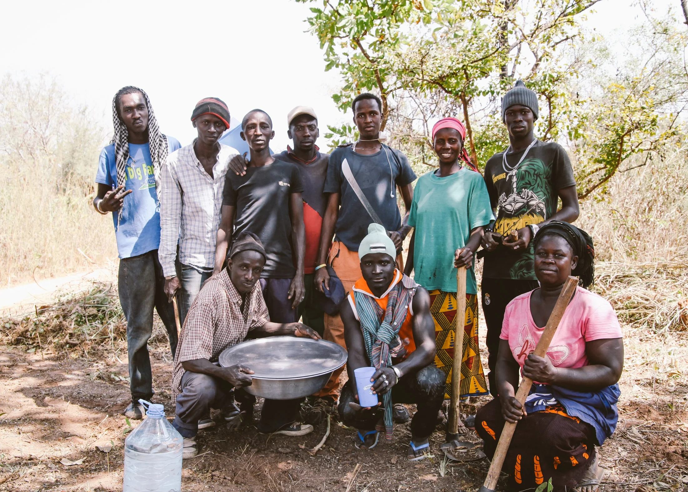 Cash-for-work laborers taking a short break from clearing trees and brush from an overgrown area