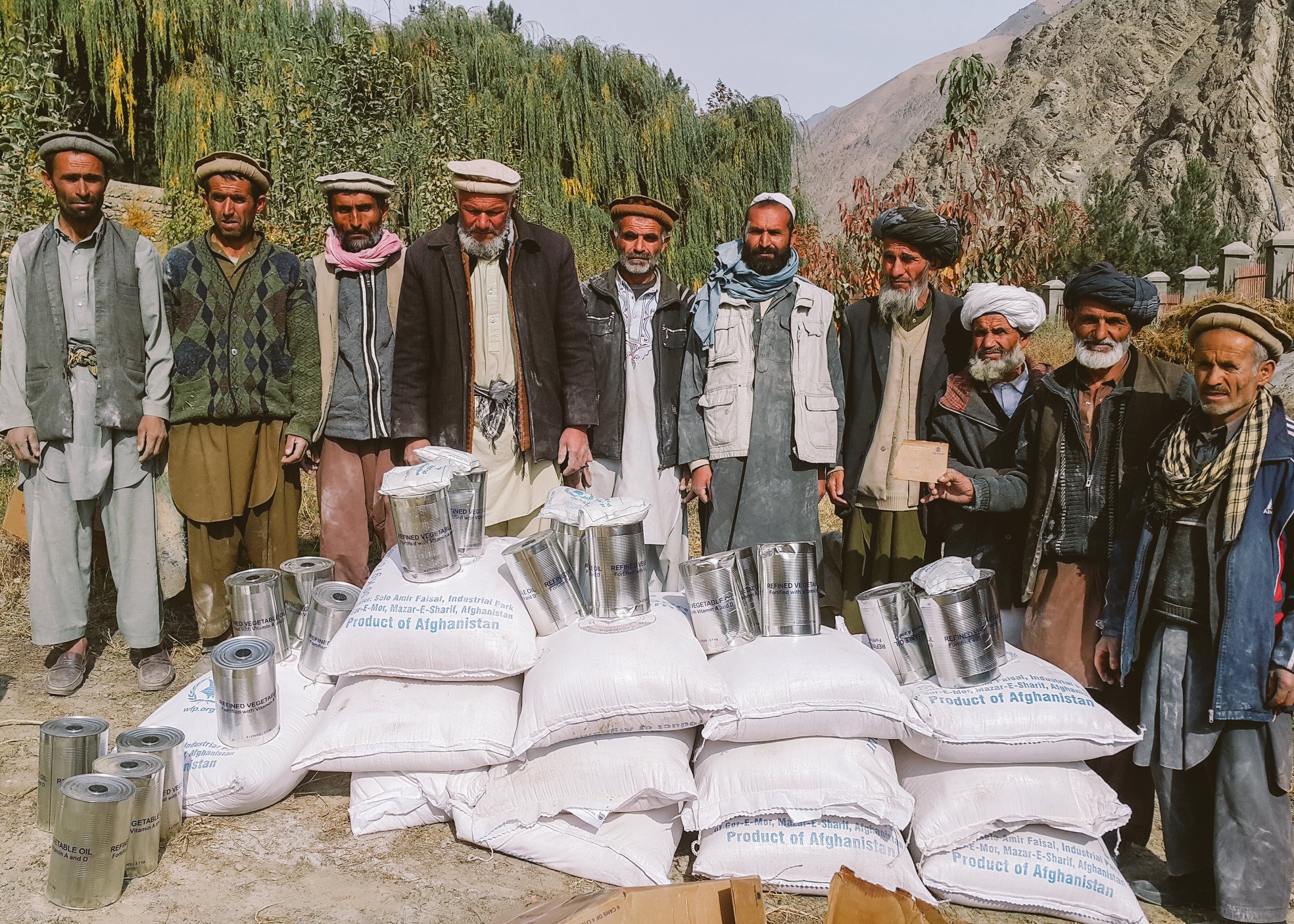  Workers receiving cooking oil and wheat in exchange for their work rehabilitating a local road and irrigation canal 