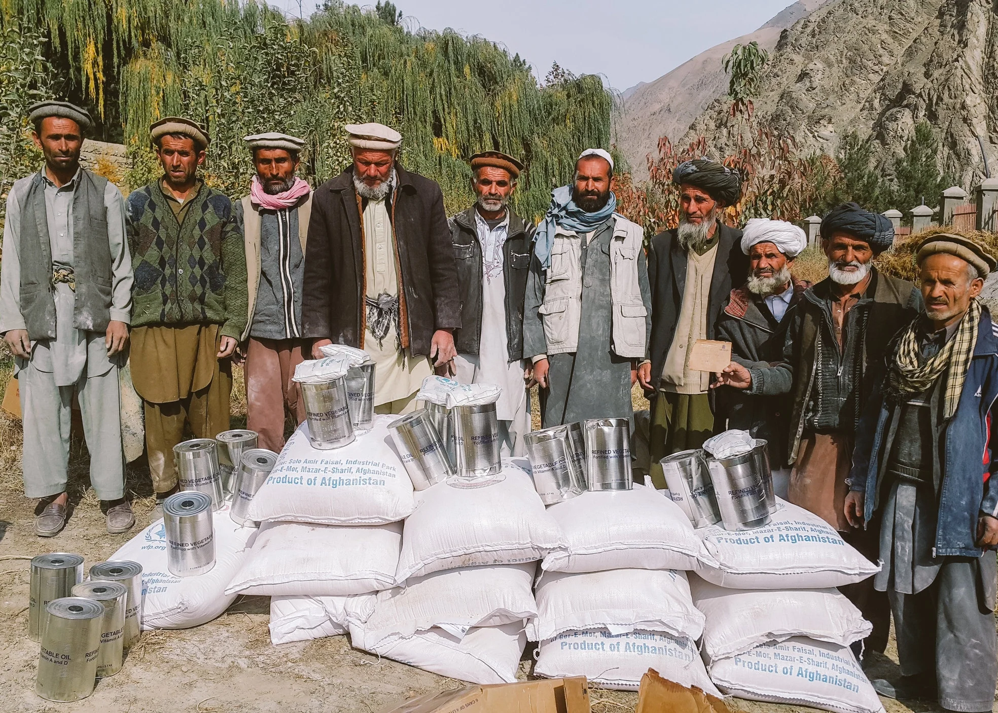 Workers receiving cooking oil and wheat in exchange for their work rehabilitating a local road and irrigation canal