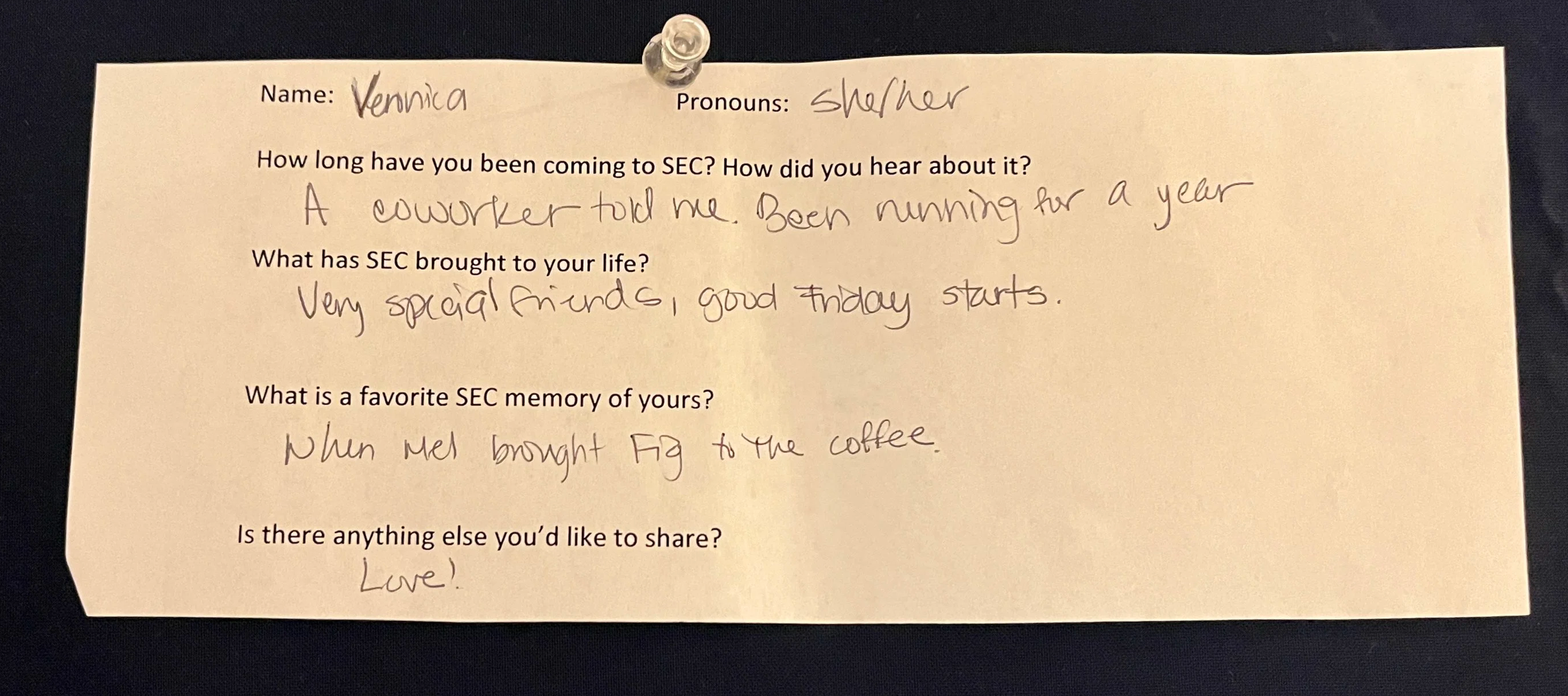 An image of a slip of paper with typed questions and hand written answers. The paper is pinned to a navy blue background with a clear thumbtack. The contents of the writing are written below the photo.