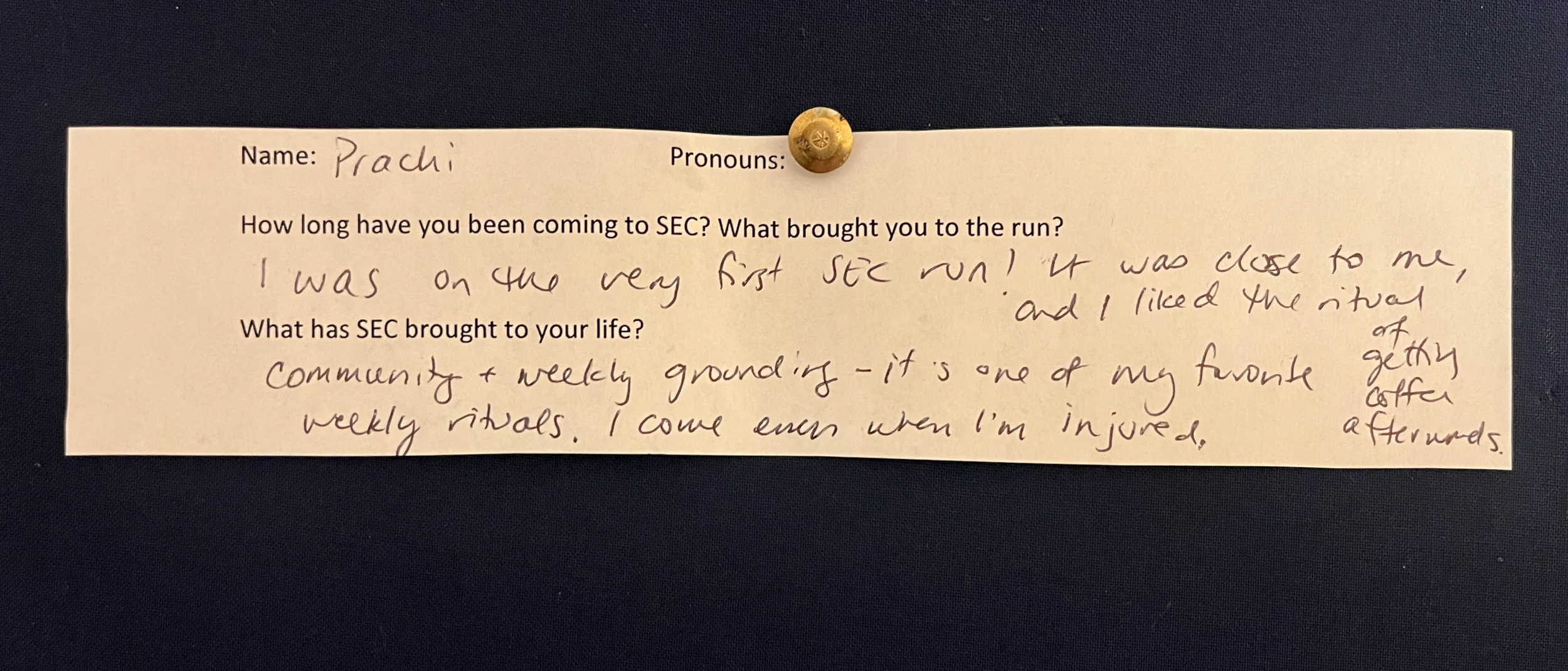 An image of a slip of paper with typed questions and hand written answers. The paper is pinned to a navy blue background with a gold metal thumbtack. The contents of the writing are written below the photo.