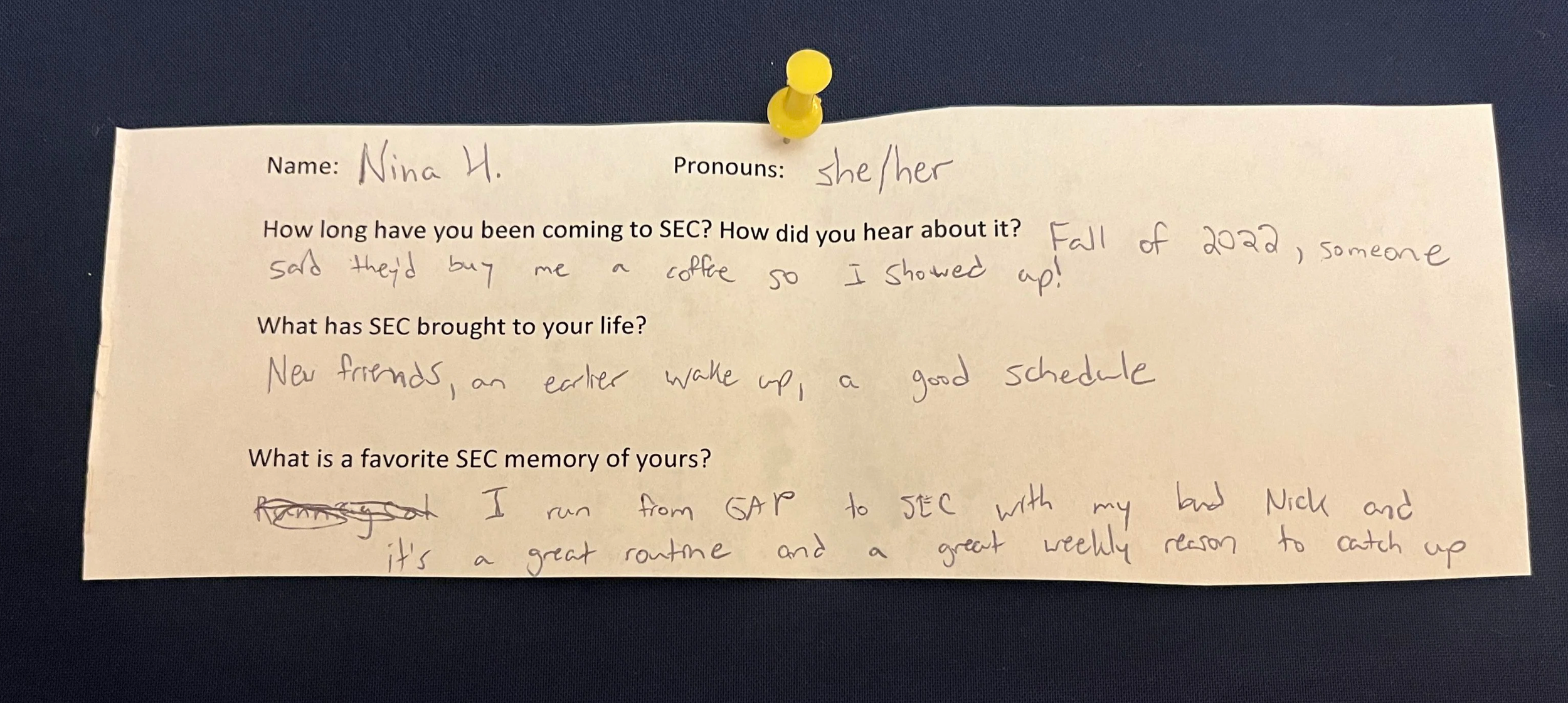 An image of a slip of paper with typed questions and hand written answers. The paper is pinned to a navy blue background with a yellow thumbtack. The contents of the writing are written below the photo.