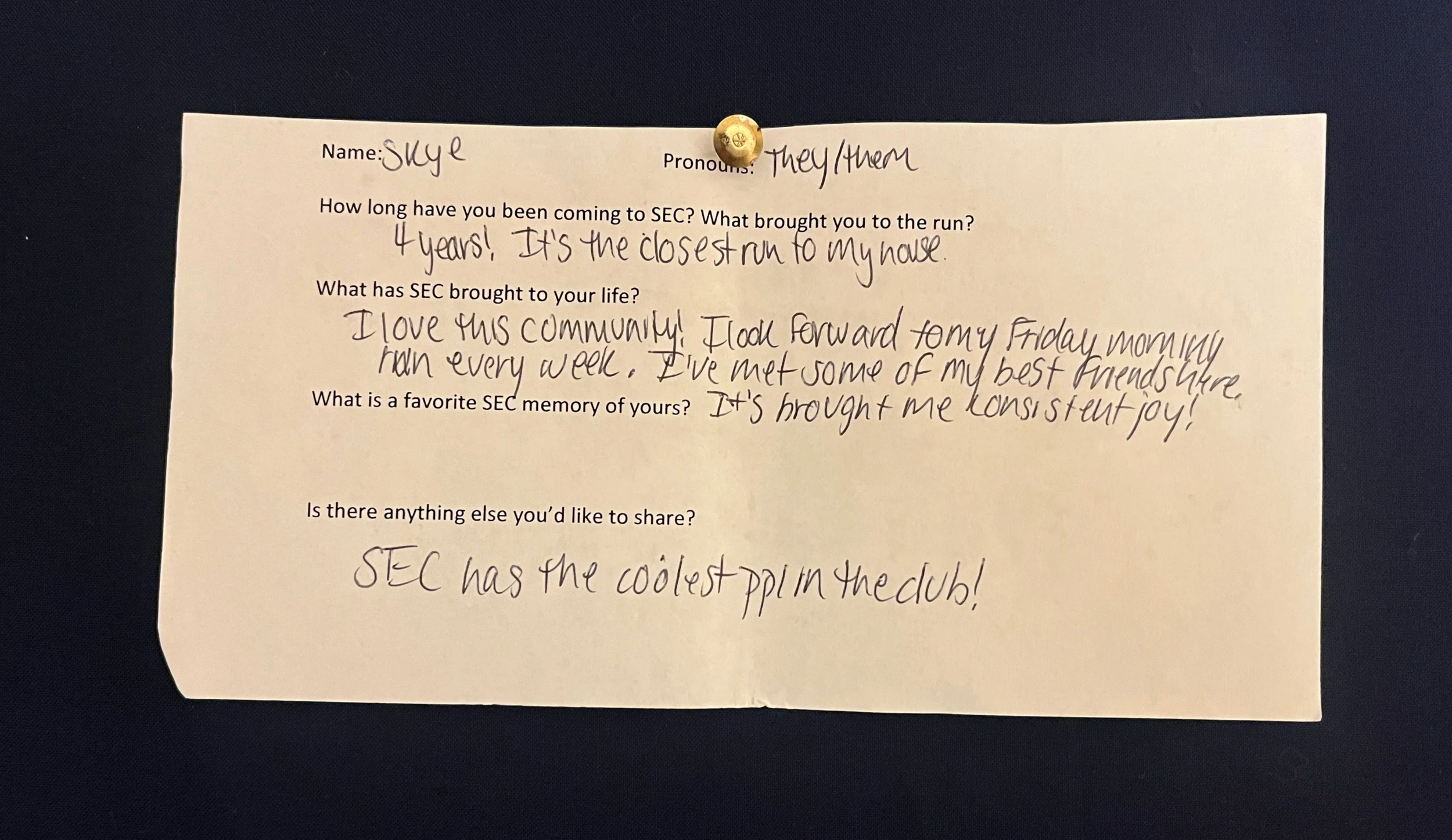 An image of a slip of paper with typed questions and hand written answers. The paper is pinned to a navy blue background with a gold metal thumbtack. The contents of the writing are written below the photo.